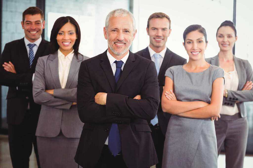 Professionelles Team aus Geschäftsleuten in Anzügen, symbolisiert Unternehmensnachfolge & Zusammenarbeit